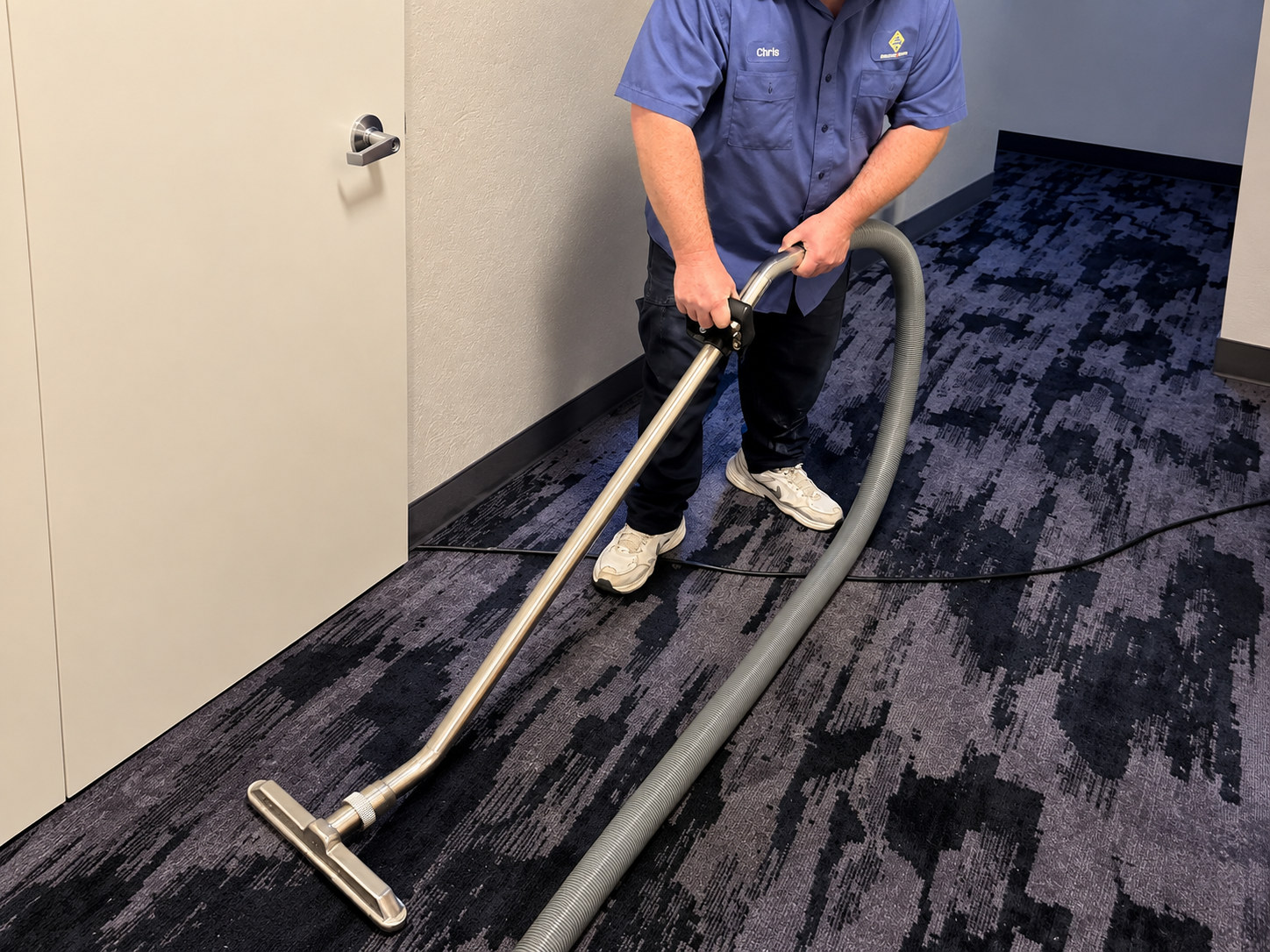 Restoration technician extracting water from a commercial corridor carpet