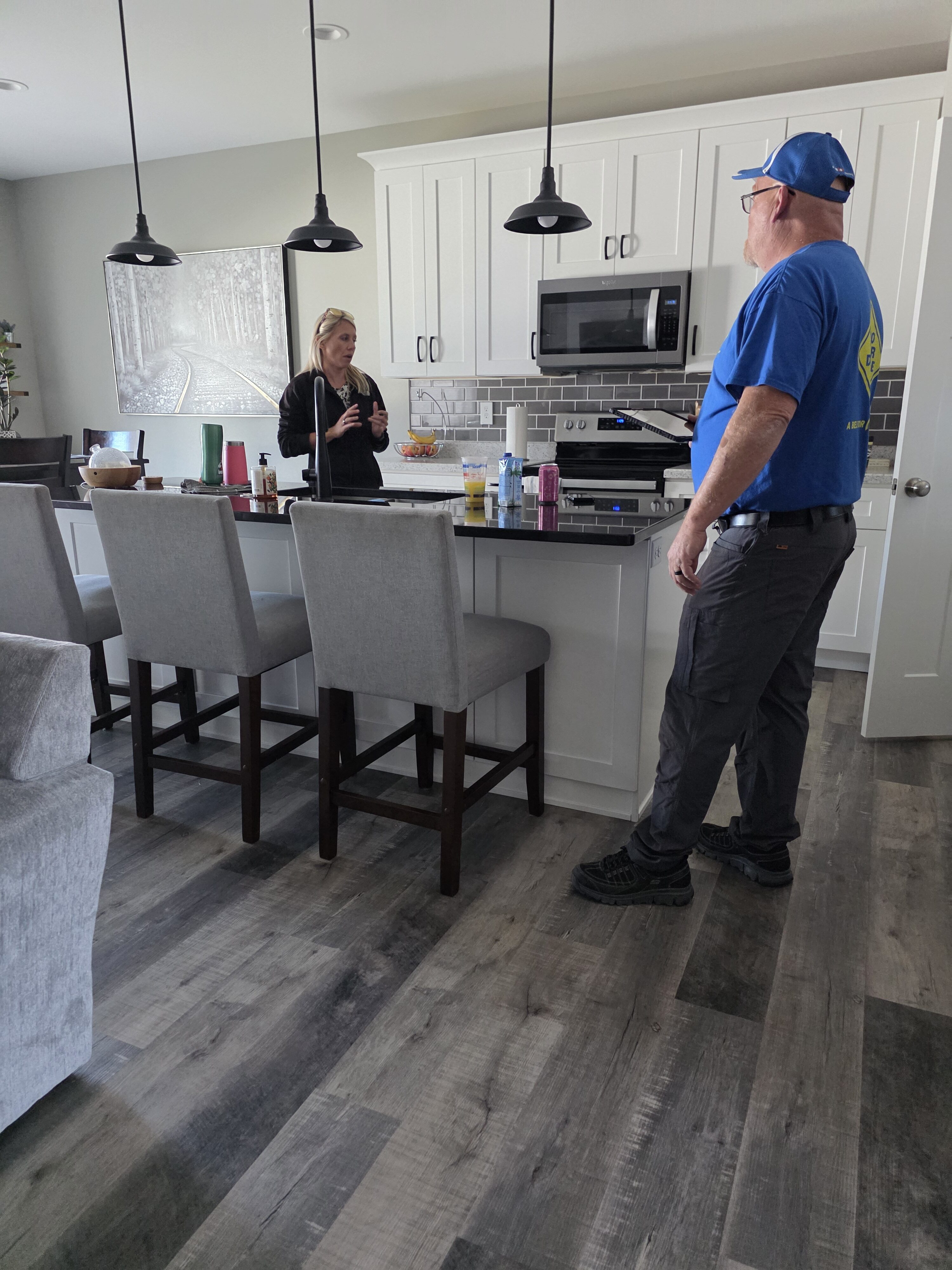 A technician explaining canine mold screening results and recommended next steps to a homeowner