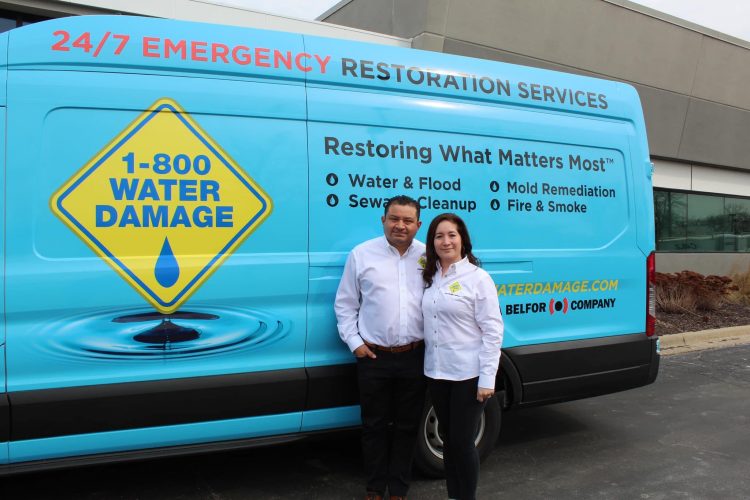 Owners Maria and Elmer Reyes standing with 1-800 WATER DAMAGE van