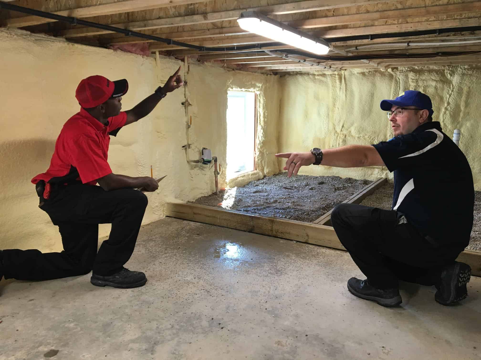 A BELFOR Technician and a 1-800 WATER DAMAGE technician inspecting a homes crawl space for water damage