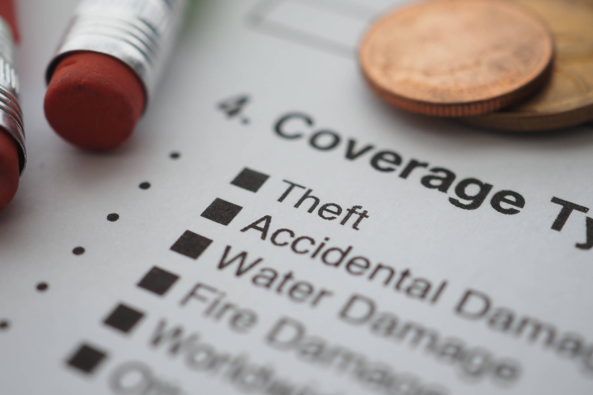 Property insurance coverage form with coins and erasers.