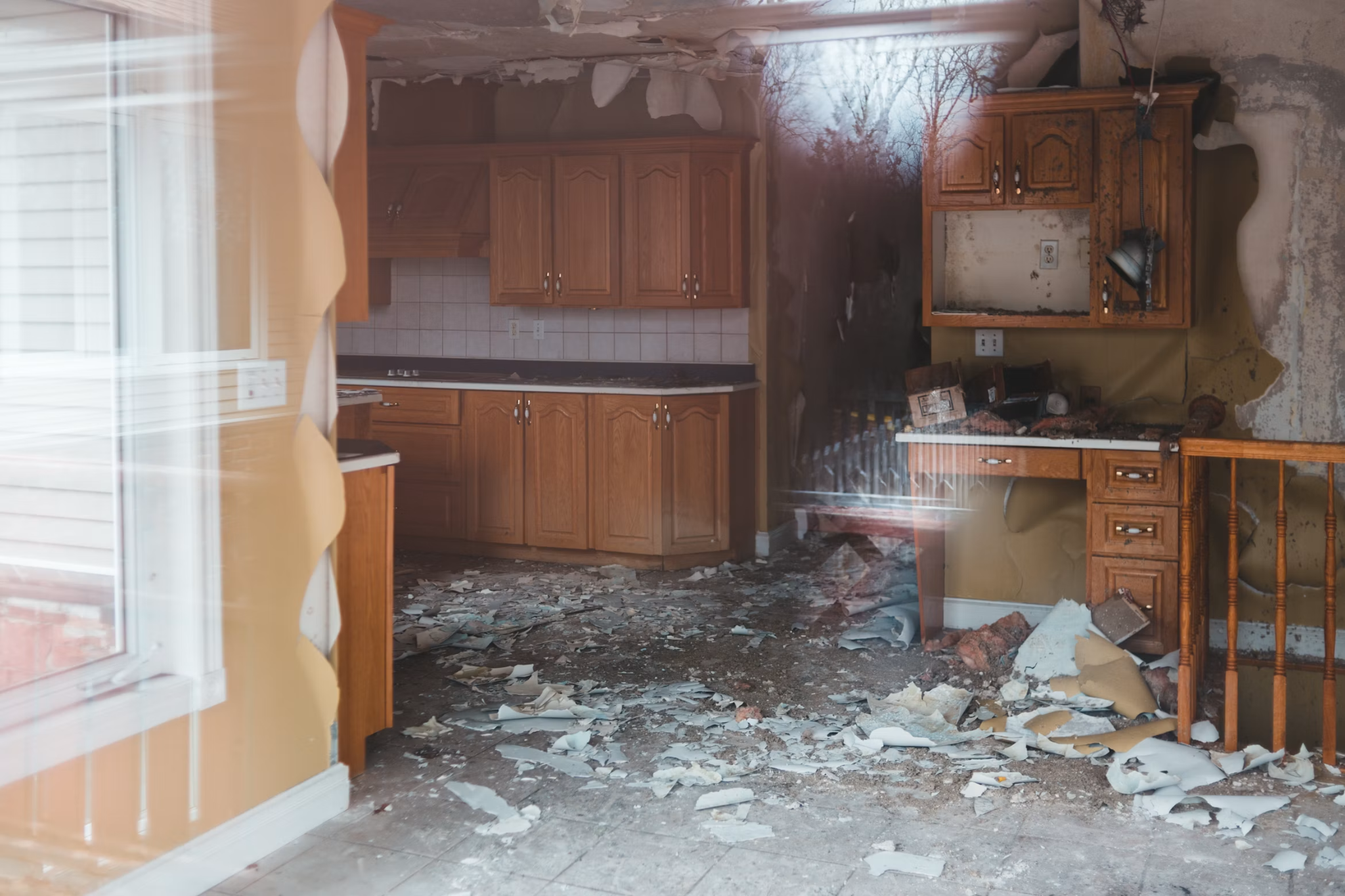 Water-damaged ceiling with brown stains, peeling paint, and cracks.