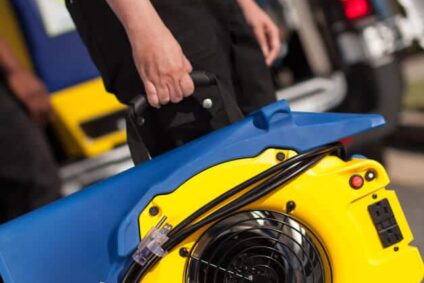 Technician standing and holding emergency restoration equipment