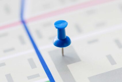 Closeup of thumbtack sticking out of map