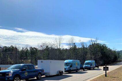 Several 1-800 WATER DAMAGE vehicles traveling down road responding to Texas winter storm