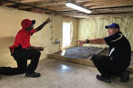 A BELFOR Technician and a 1-800 WATER DAMAGE technician inspecting a homes crawl space for water damage
